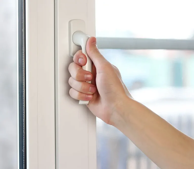 Hand turning a white window handle