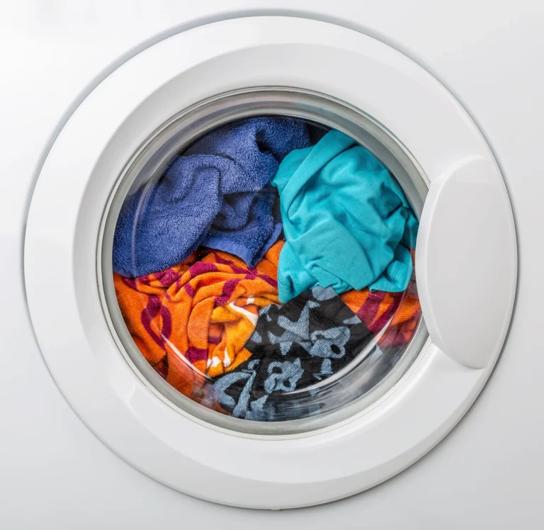 Colourful clothes inside a front-loading washing machine