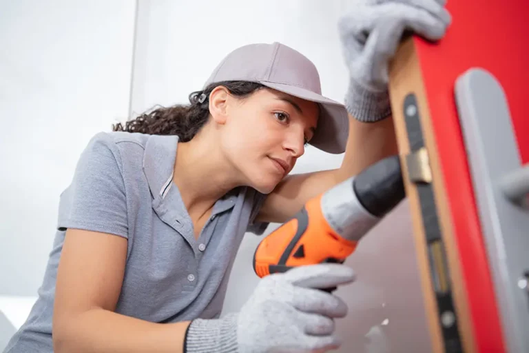Woman drilling wall while checking alignment with spirit level
