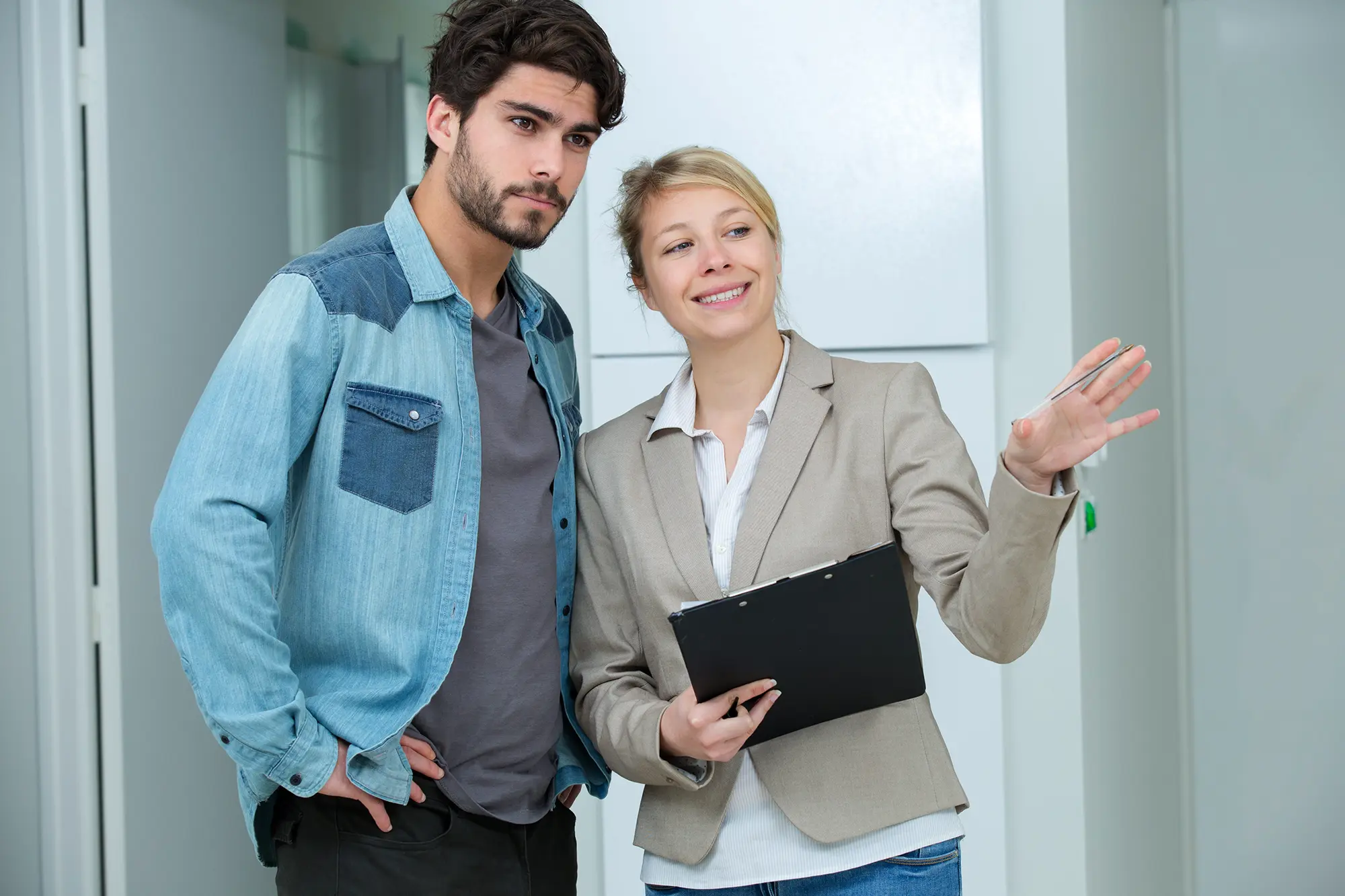 Estate agent showing prospective buyer around a bright property