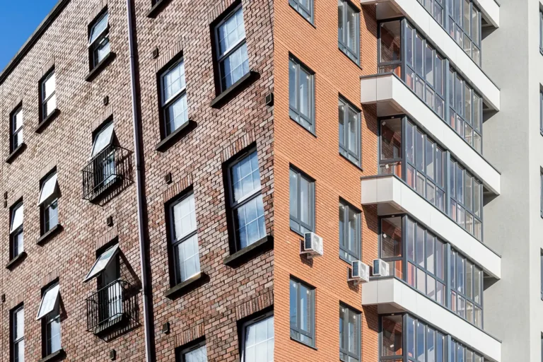 Brick apartment buildings with windows, balconies and air-conditioning units
