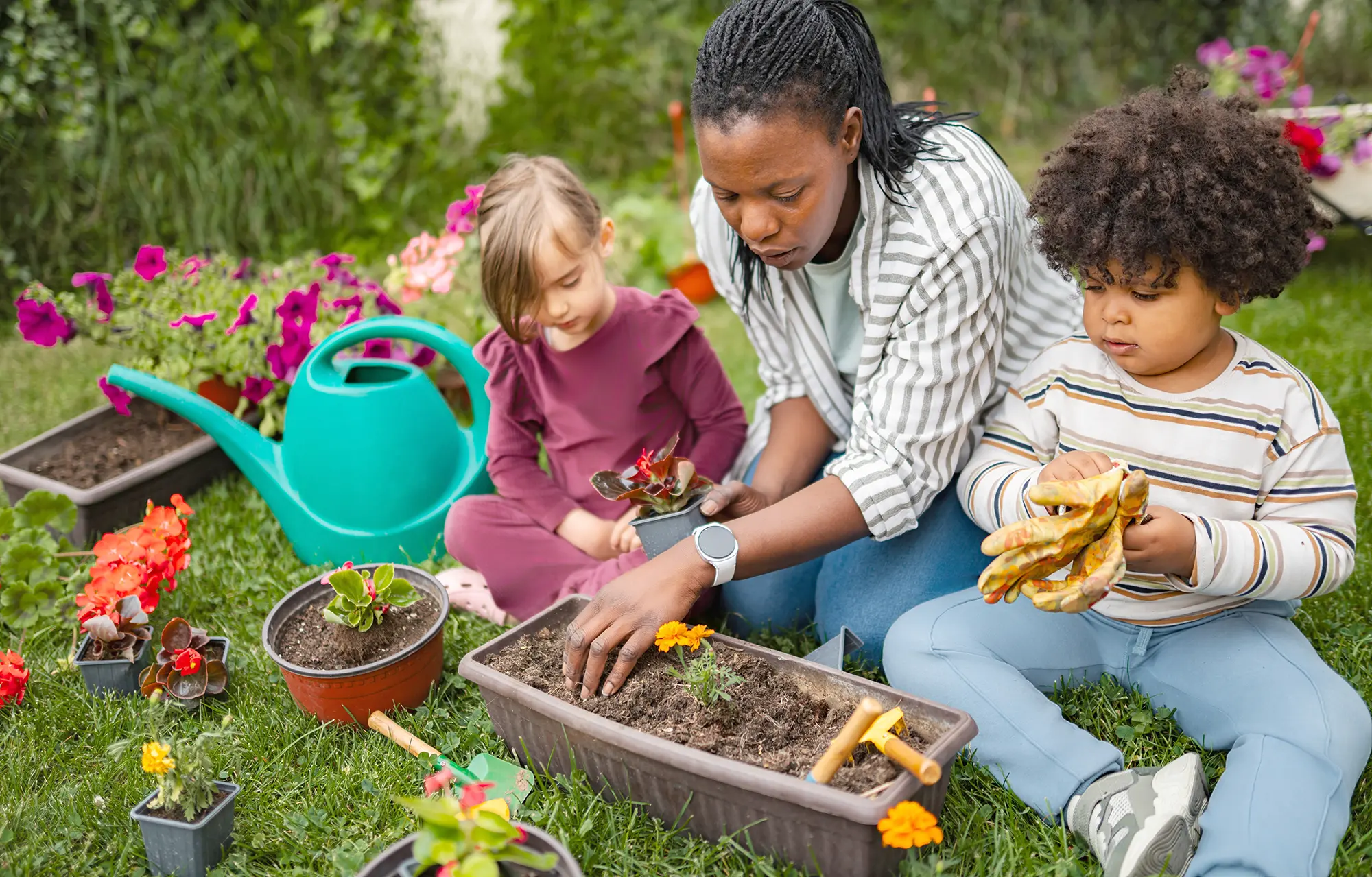 Adult and children planting flowers together in a garden