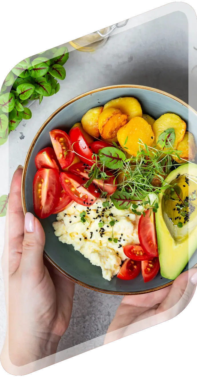 Breakfast bowl with eggs, avocado, tomatoes, potatoes and microgreens