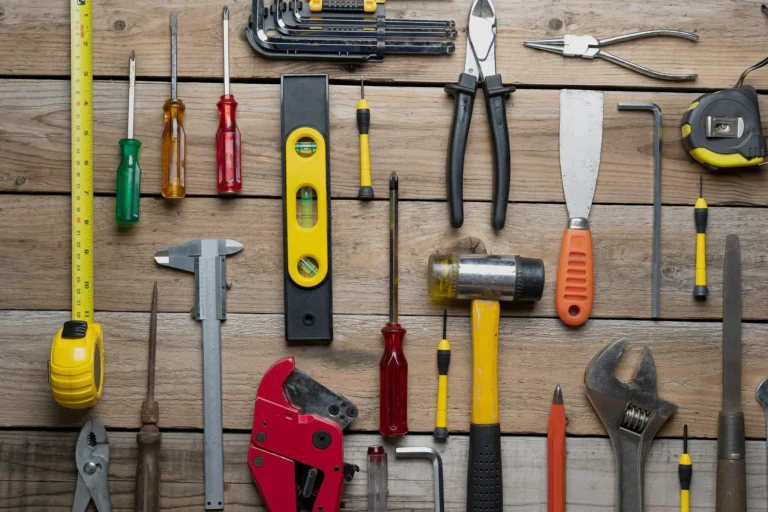 Assorted hand tools arranged on a wooden workbench