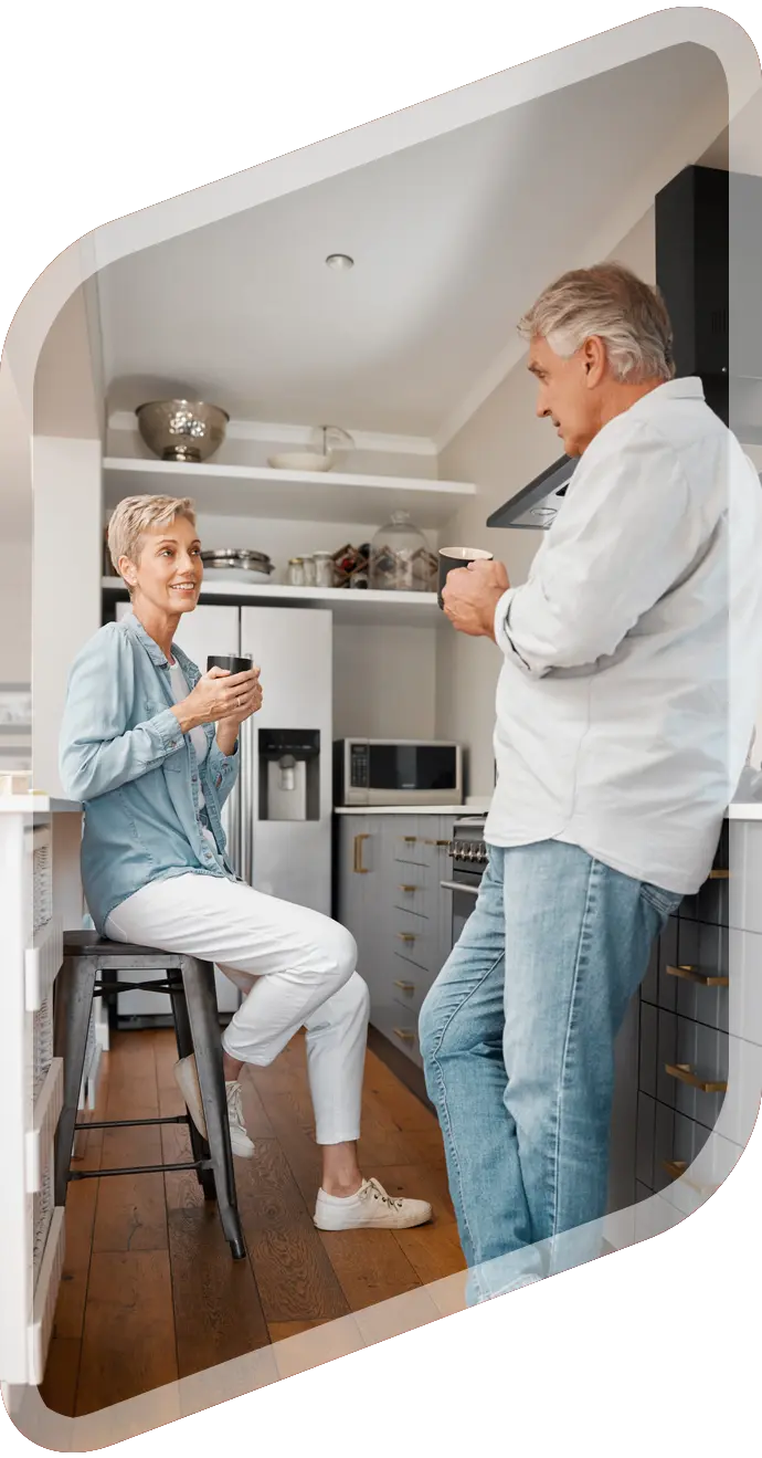 Older couple chatting over coffee in a modern kitchen